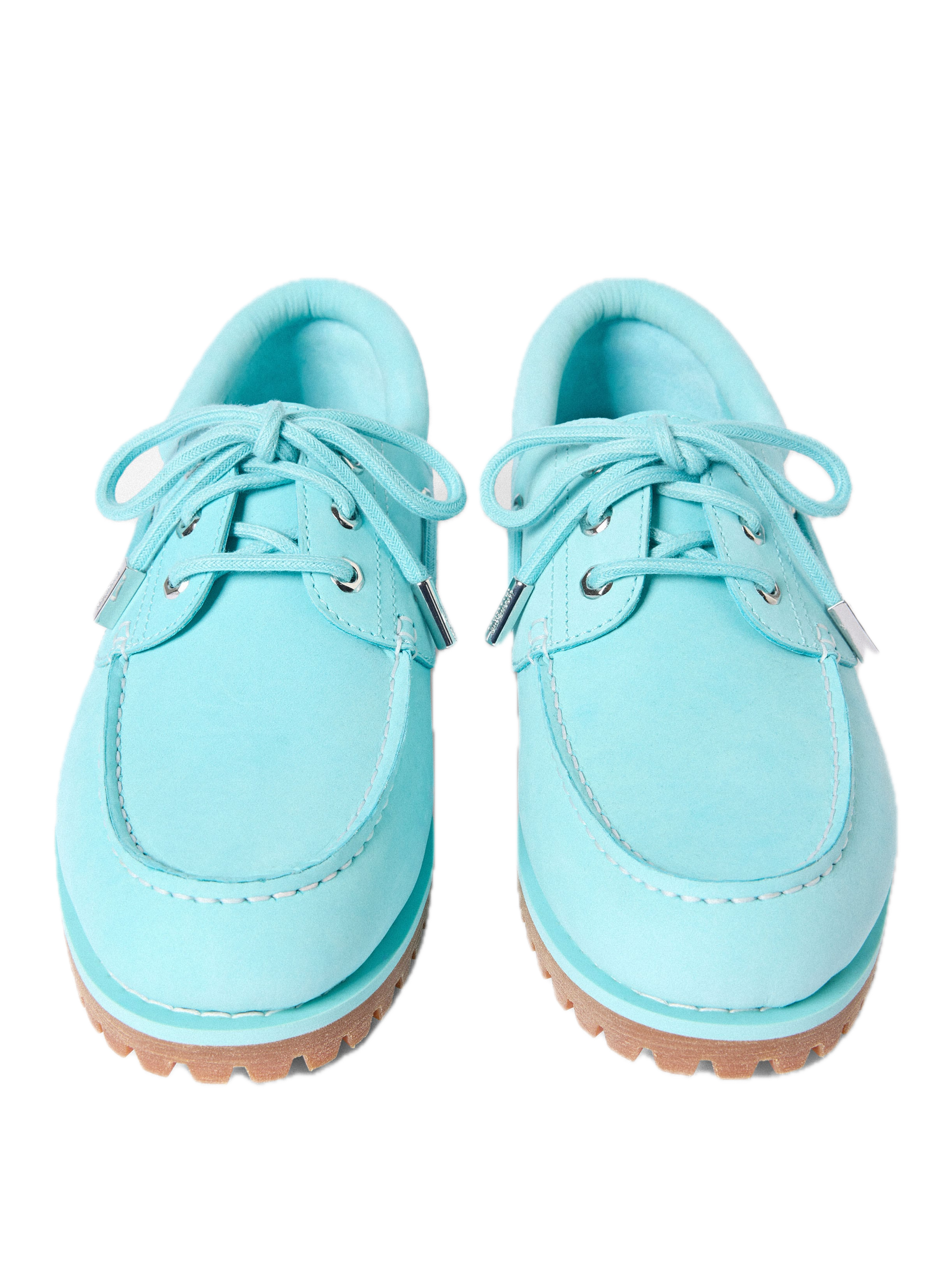 Side profile of the Timberland x Jacquemus Authentic Boat Shoe in Lagoon Blue featuring premium leather, silver eyelets, matching laces, and a classic lug sole.